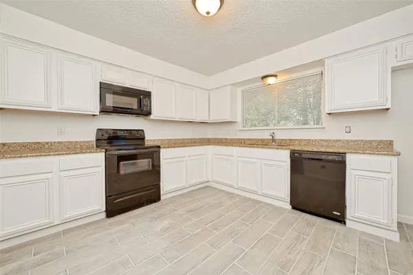 a kitchen with a sink cabinets stainless steel appliances and a window