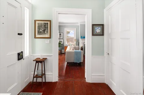 a view of a hallway with wooden floor and a livingroom