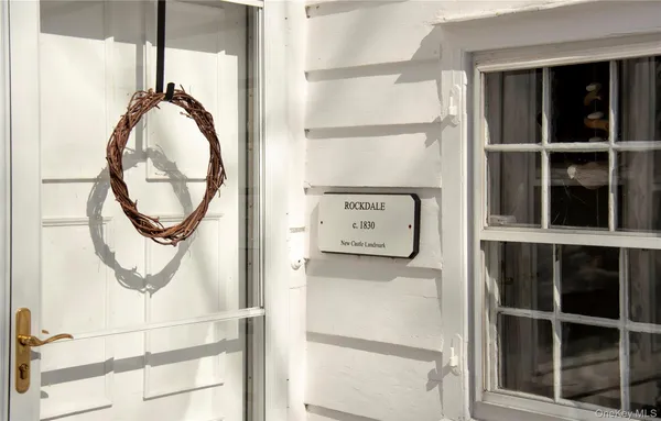 a view of a patio with table and chairs potted plants and large tree