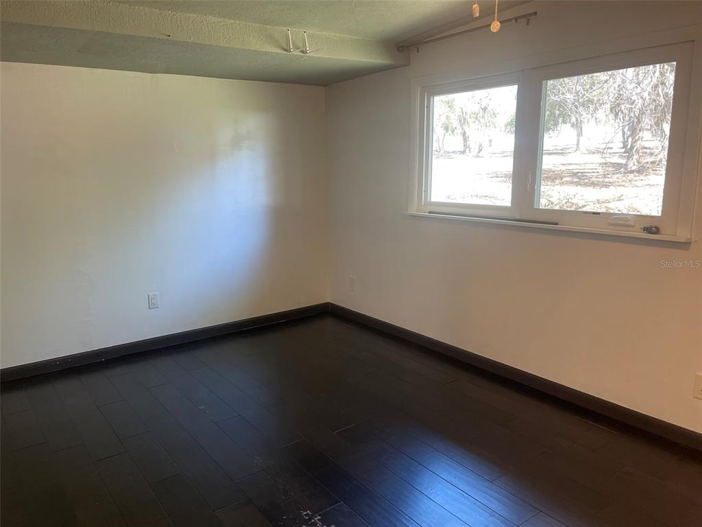 10140 Lake Louisa Road, Unit A Clermont, FL 34711 - Photo 13 of 18 an empty room with wooden floor and windows