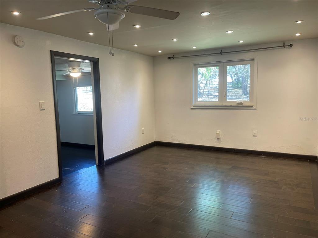 10140 Lake Louisa Road, Unit A Clermont, FL 34711 - Photo 4 of 18 an empty room with wooden floor and windows