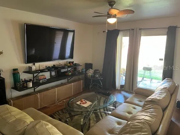 a living room with furniture a clock on wall and a flat screen tv