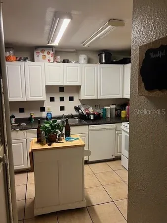 a kitchen with stainless steel appliances kitchen island granite countertop a sink and a refrigerator