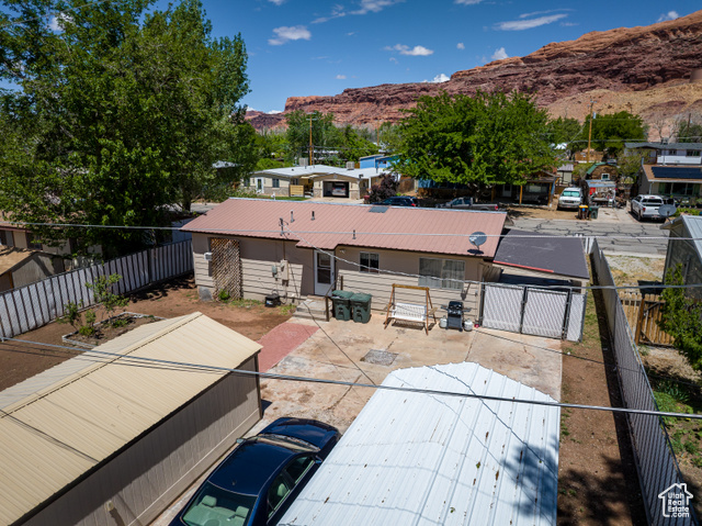 527 Palisade Drive Moab, UT 84532 - Photo 36 of 51 Back of property featuring a mountain view, metal roof, a fenced backyard, and a gate