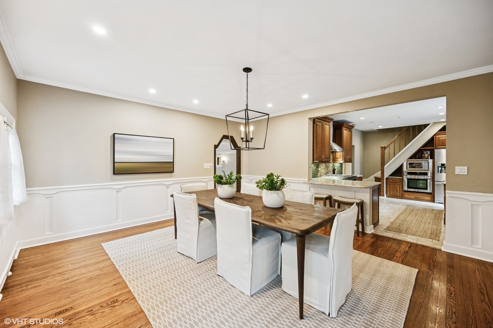 1487 Tower Road Winnetka, IL 60093 - Photo 17 of 45 a dining room with wooden floor a chandelier a wooden table and chairs
