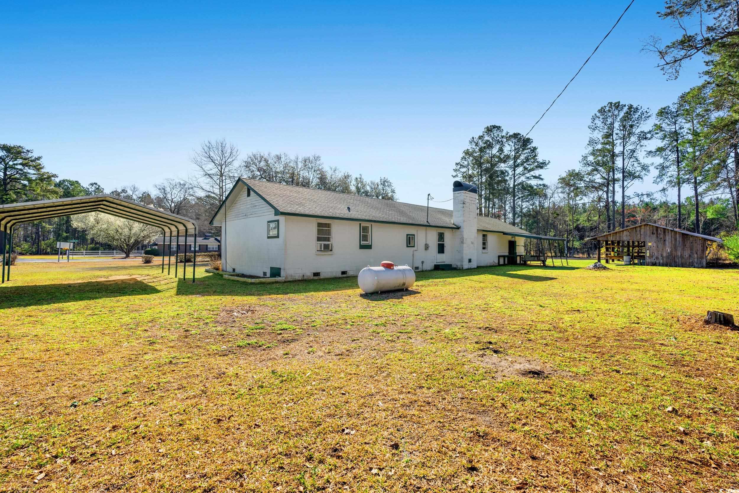 1861 Jenerette Street Mullins, SC 29574 - Photo 25 of 36 Back of property with a lawn, a detached carport, and a chimney