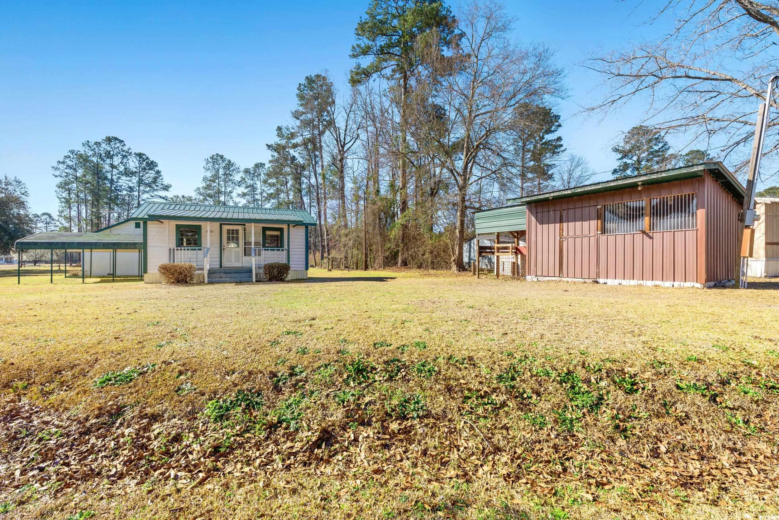 1861 Jenerette Street Mullins, SC 29574 - Photo 27 of 36 View of yard featuring an outbuilding, a carport, and a porch