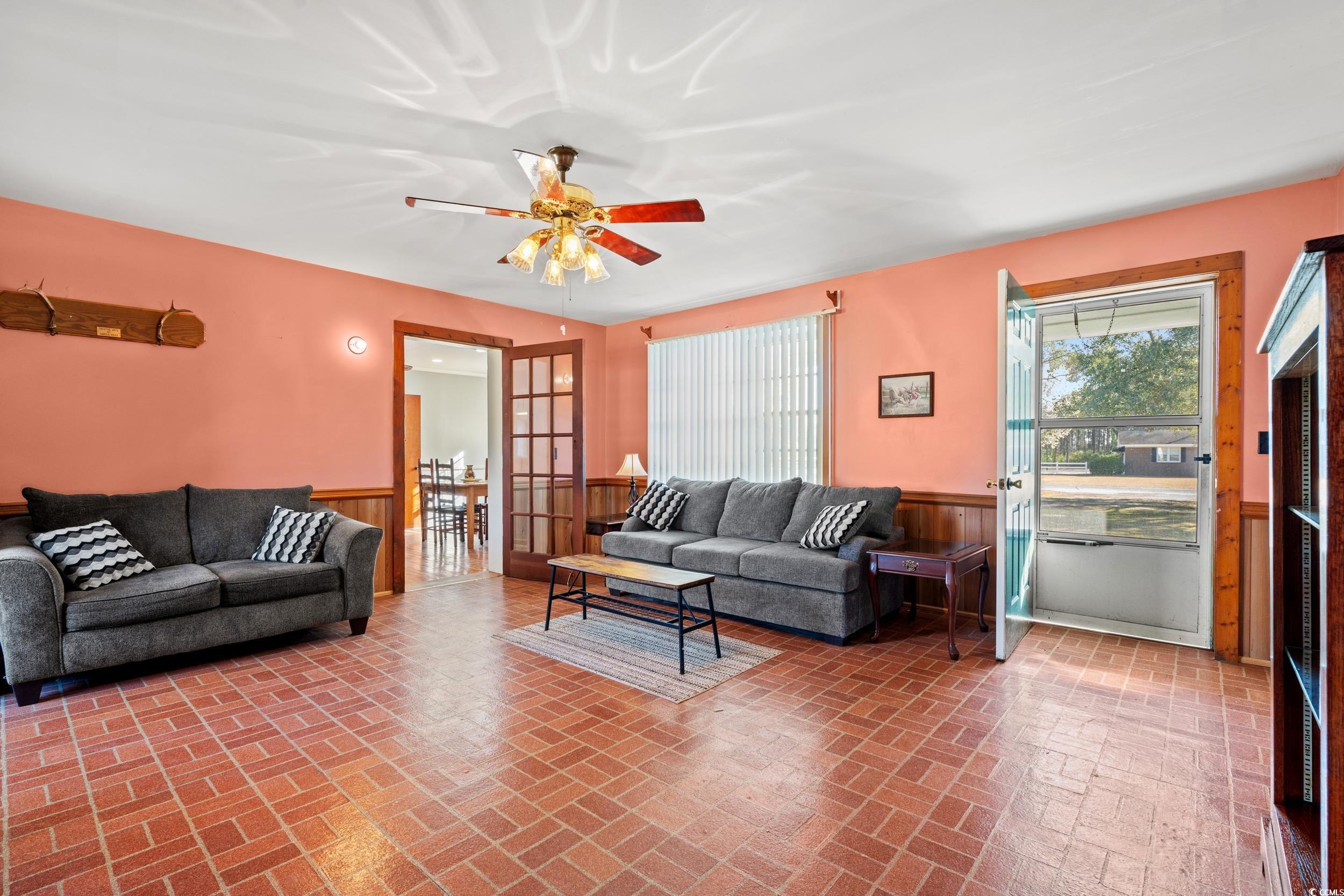 1861 Jenerette Street Mullins, SC 29574 - Photo 7 of 36 Living room with wainscoting, brick floor, and ceiling fan