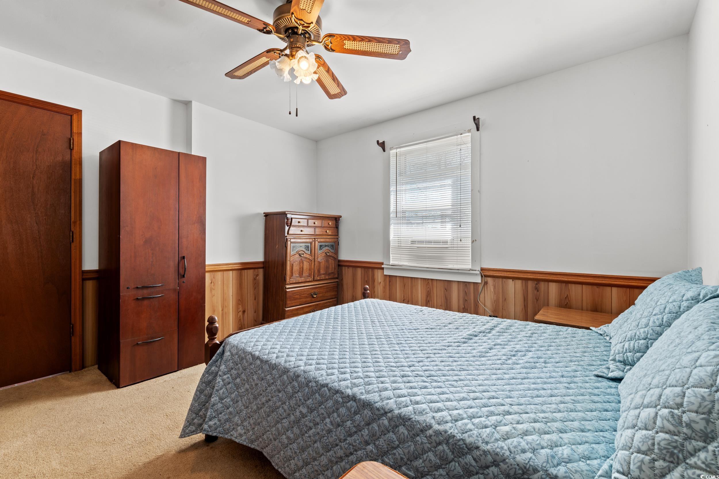 1861 Jenerette Street Mullins, SC 29574 - Photo 10 of 36 Bedroom with carpet flooring, wainscoting, a ceiling fan, and wood walls