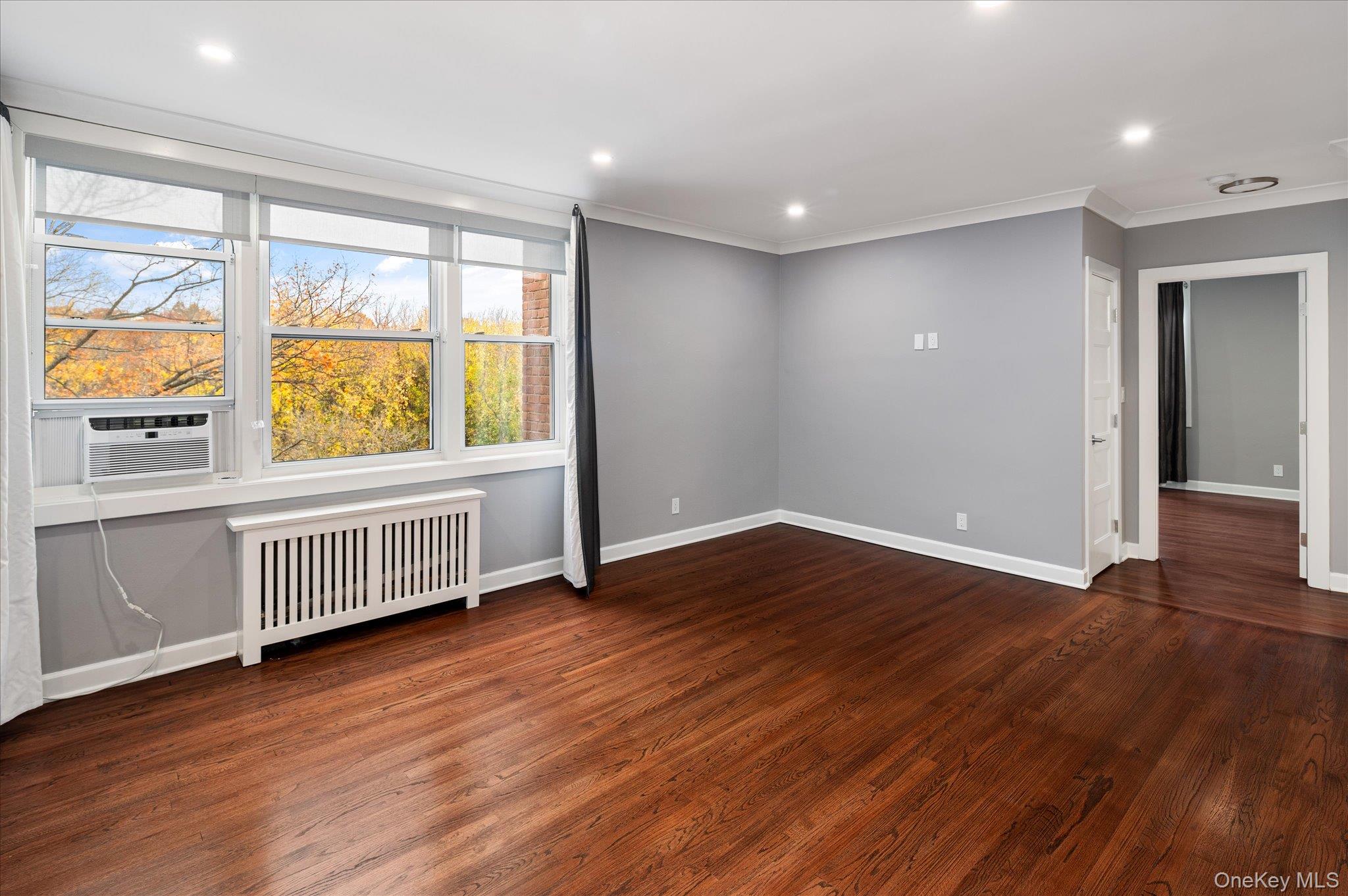 1133 Midland Avenue, Unit 4C Bronxville, NY 10708 - Photo 9 of 30 a view of an empty room with wooden floor and a window