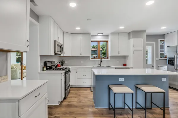 a kitchen with a refrigerator a stove a sink and a stove with wooden floor