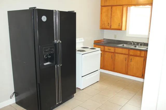 a kitchen with stainless steel appliances granite countertop a refrigerator and a stove