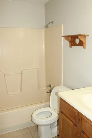 a white toilet sitting next to a bath tub