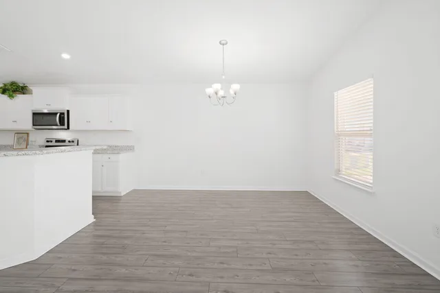 a kitchen with stainless steel appliances granite countertop a sink a stove a microwave a refrigerator and a potted plant