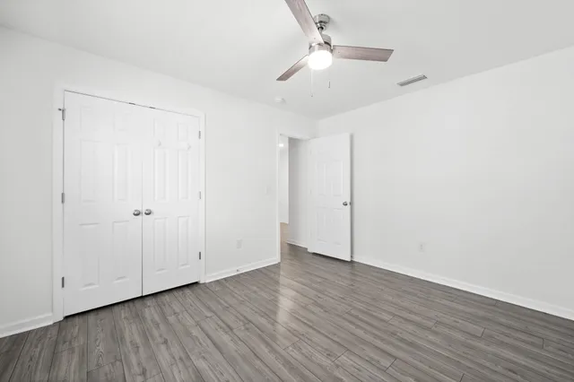 a view of swimming pool with lawn chairs and large trees