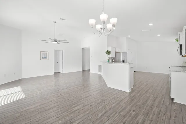 a view of a kitchen with a sink dishwasher and microwave with wooden floor
