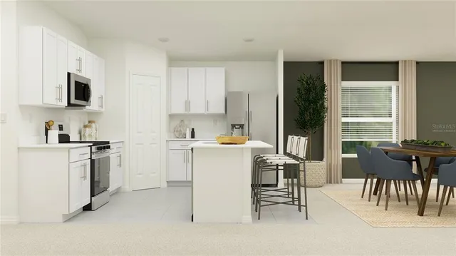 a kitchen with a table chairs microwave and cabinets