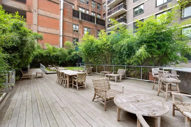 a view of a roof deck with table and chairs and wooden floor