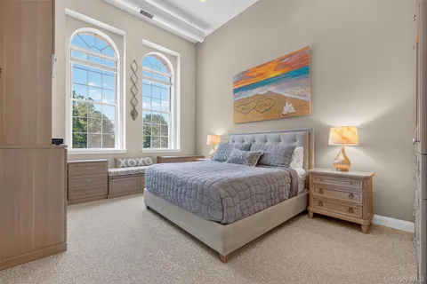 a bedroom with a bed dresser and window