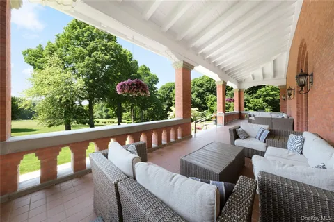 a balcony with wooden floor and outdoor seating