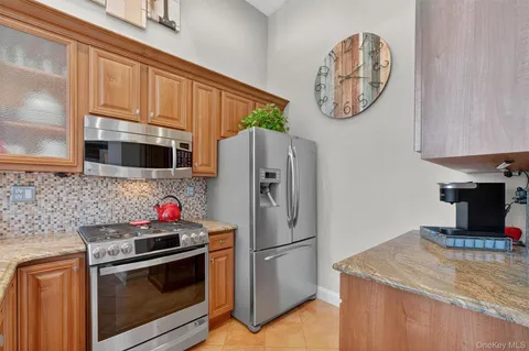 a kitchen with stainless steel appliances granite countertop a refrigerator and a stove top oven