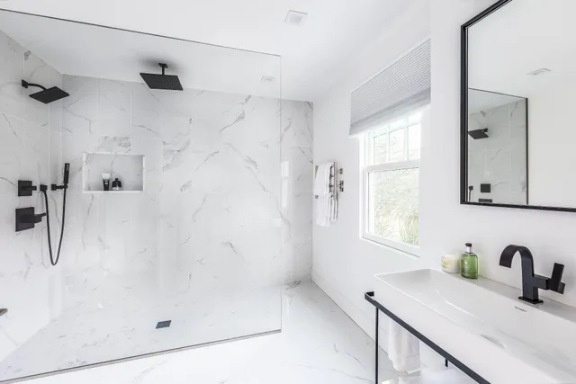 a spacious bedroom with a bed couch and a flat tv screen