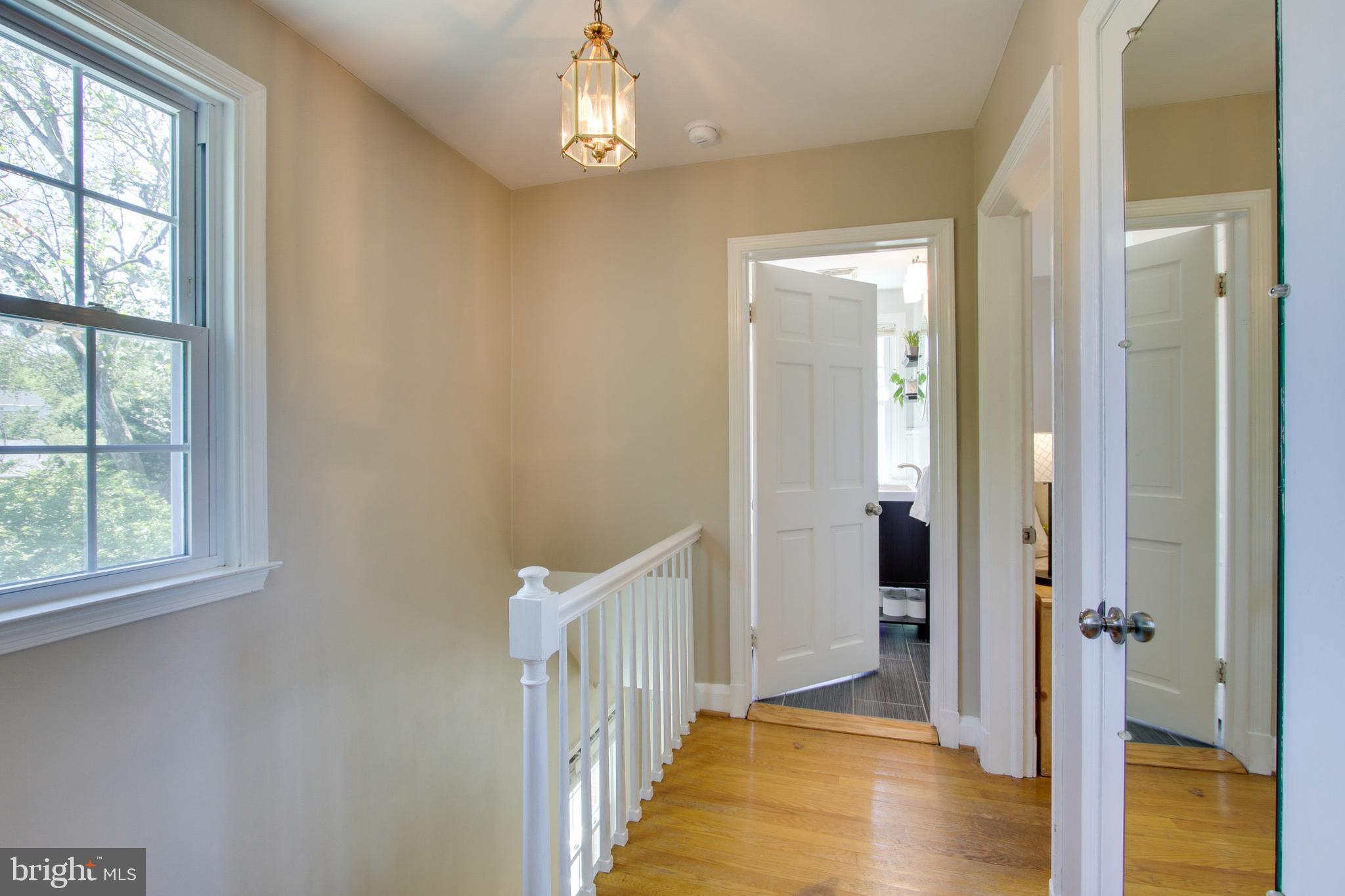 607 Worcester Road Baltimore, MD 21286 - Photo 30 of 42 a view of a hallway with wooden floor and a bathroom