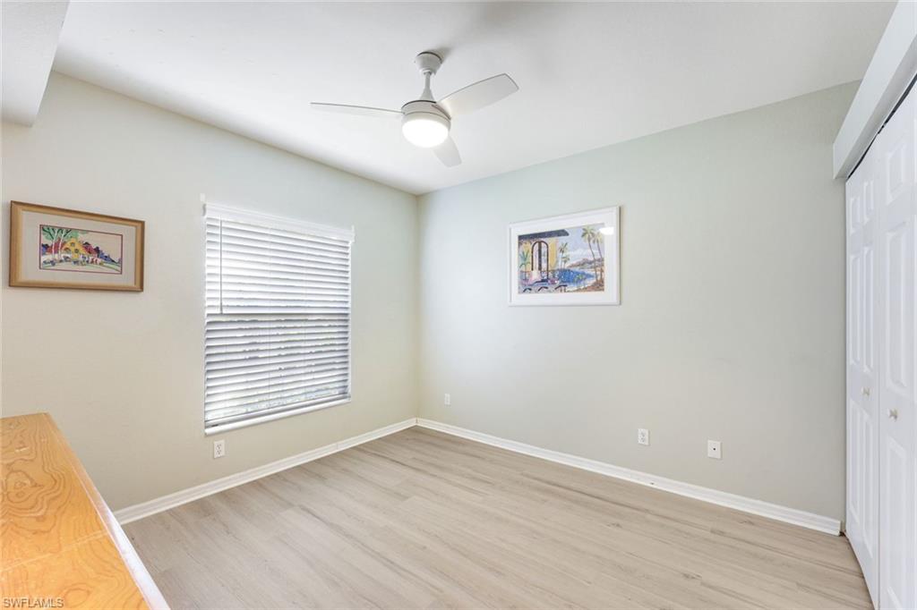 23861 Costa Del Sol Road, Unit 103 Estero, FL 34135 - Photo 12 of 29 a view of an empty room with a window and wooden floor