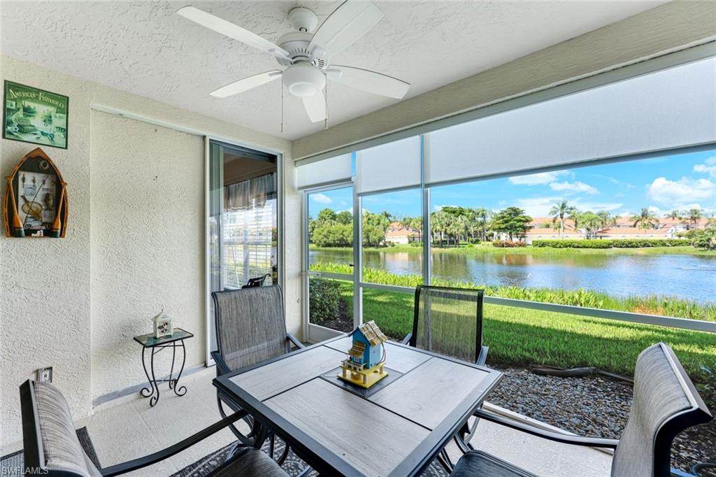 23861 Costa Del Sol Road, Unit 103 Estero, FL 34135 - Photo 15 of 29 a living room with a floor to ceiling window and a table