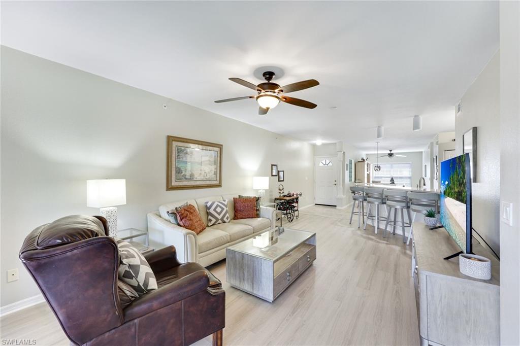 23861 Costa Del Sol Road, Unit 103 Estero, FL 34135 - Photo 2 of 29 a living room with furniture a ceiling fan and a rug