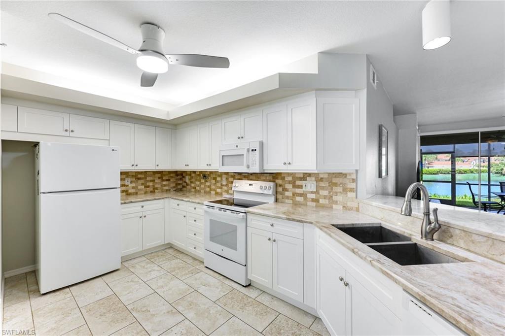 23861 Costa Del Sol Road, Unit 103 Estero, FL 34135 - Photo 3 of 29 a kitchen with a sink a refrigerator and cabinets