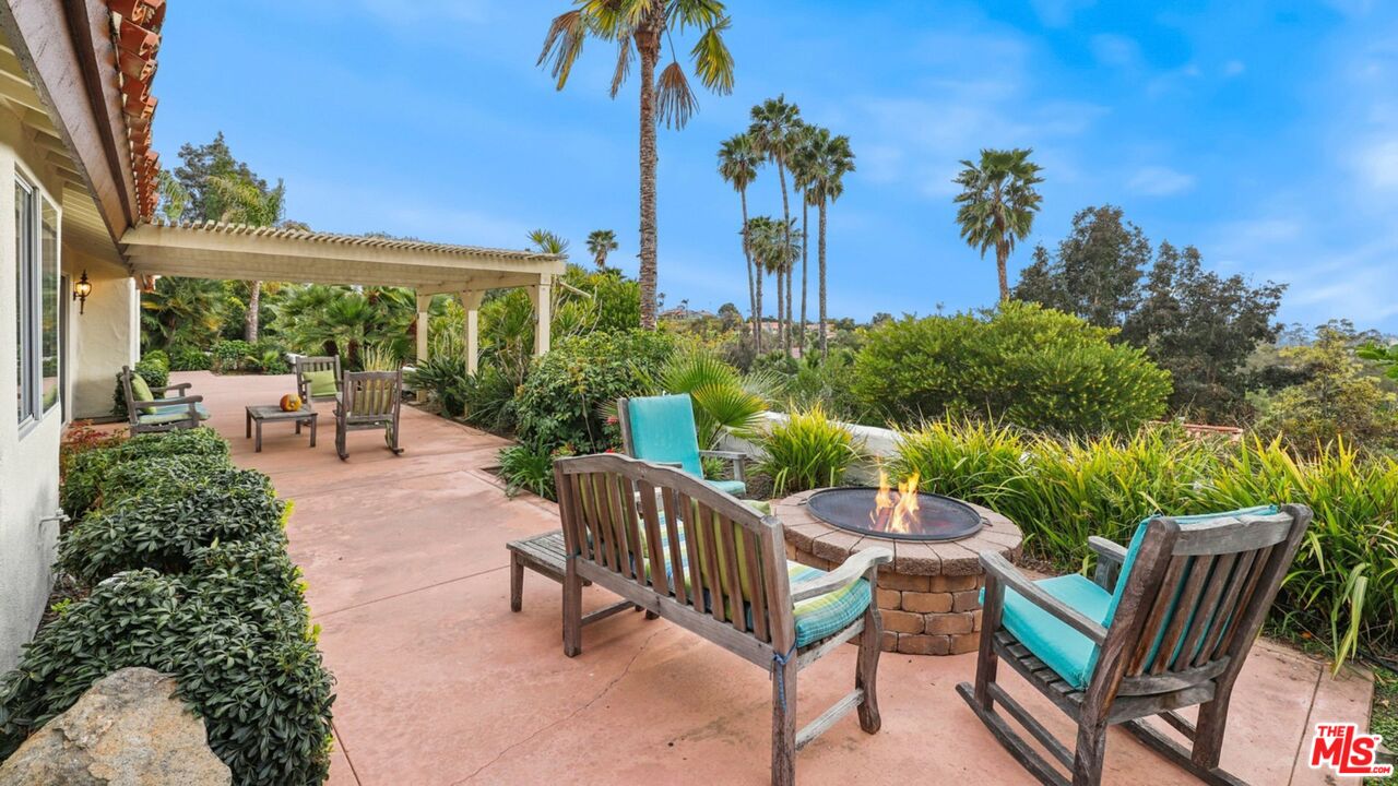 3548 Rosa Way Fallbrook, CA 92028 - Photo 40 of 49 a view of a patio with table and chairs potted plants and palm tree