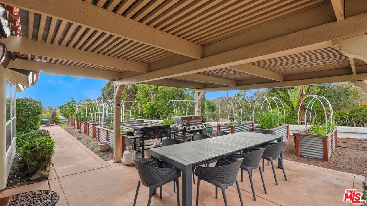 3548 Rosa Way Fallbrook, CA 92028 - Photo 42 of 49 a view of a patio with a table chairs and a backyard