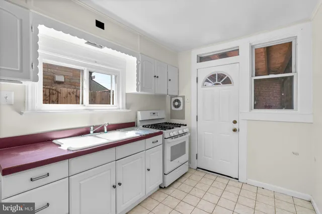 a kitchen with granite countertop white cabinets and white appliances