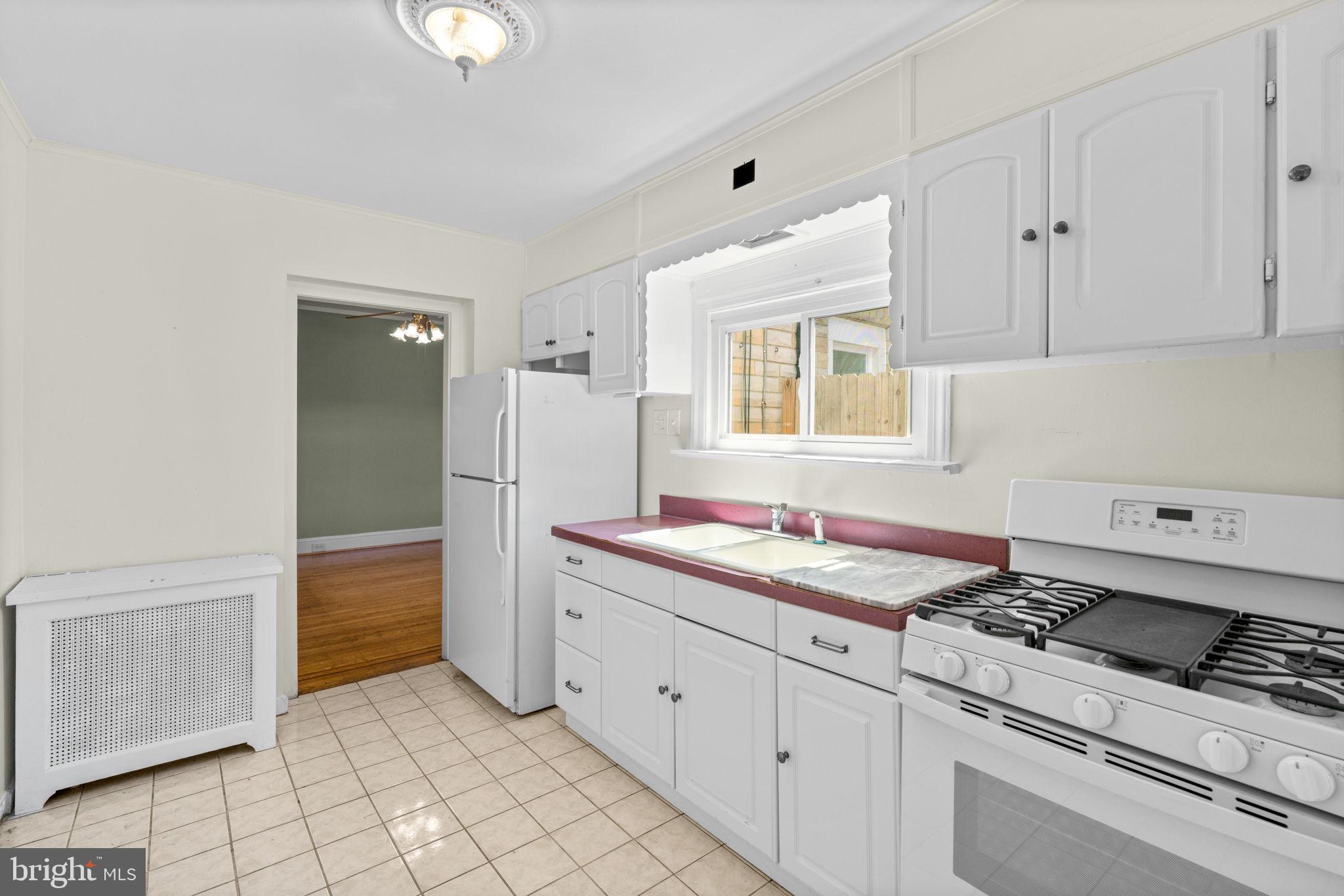 310 Drew Street Baltimore, MD 21224 - Photo 15 of 47 a kitchen with granite countertop white cabinets and white appliances