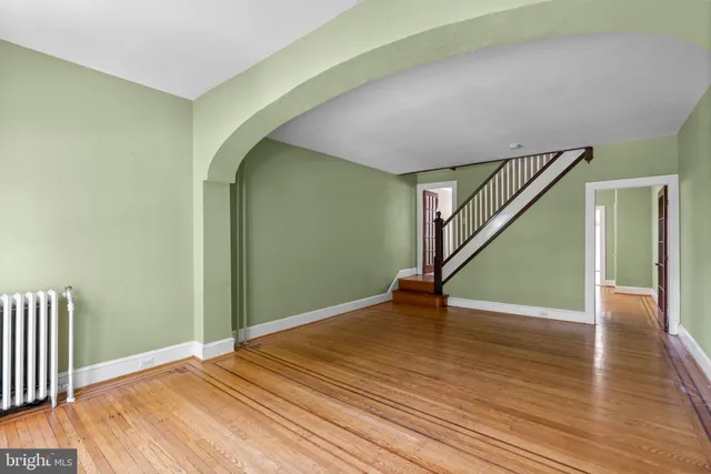 a view of an empty room with wooden floor