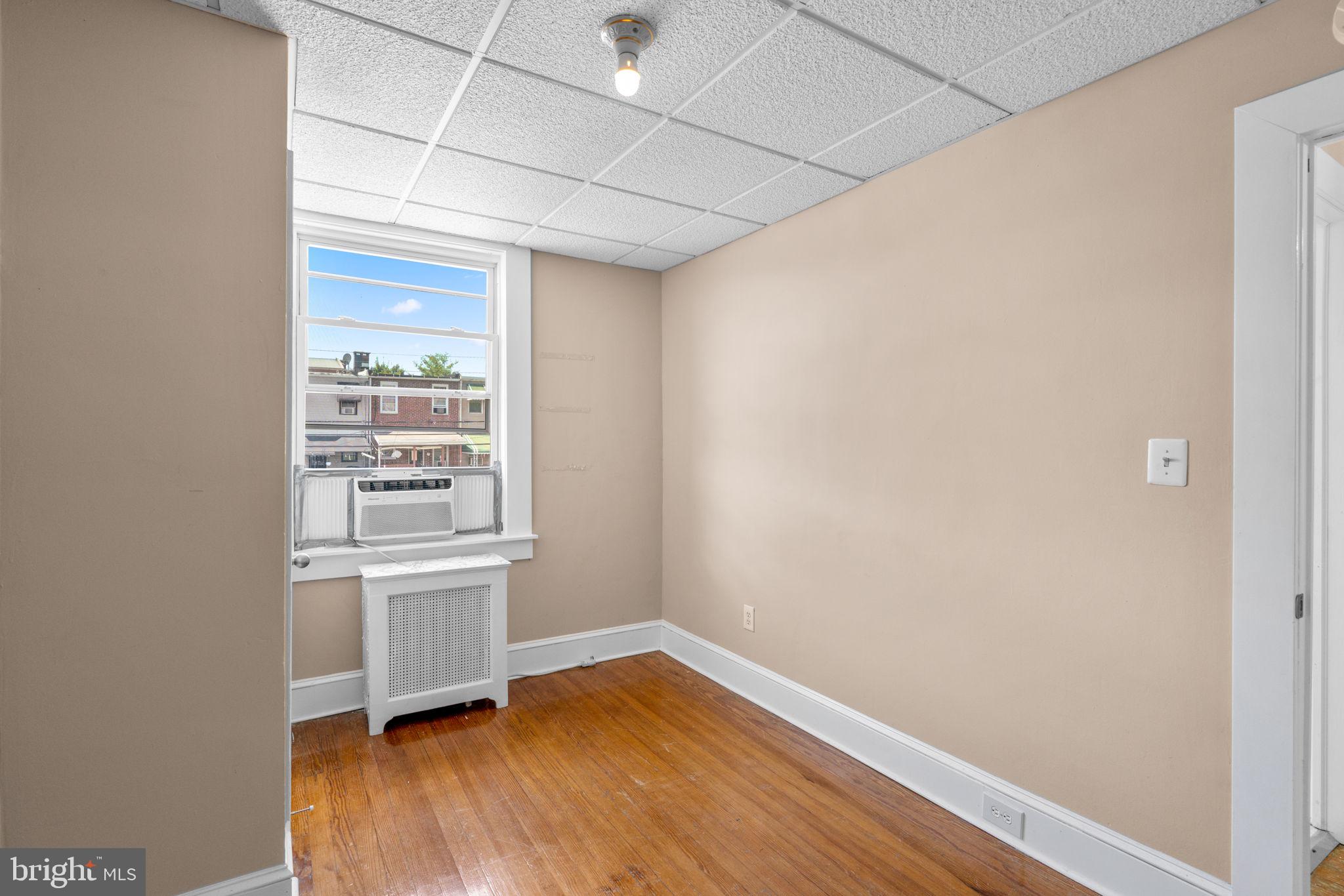 310 Drew Street Baltimore, MD 21224 - Photo 23 of 47 an empty room with wooden floor and window