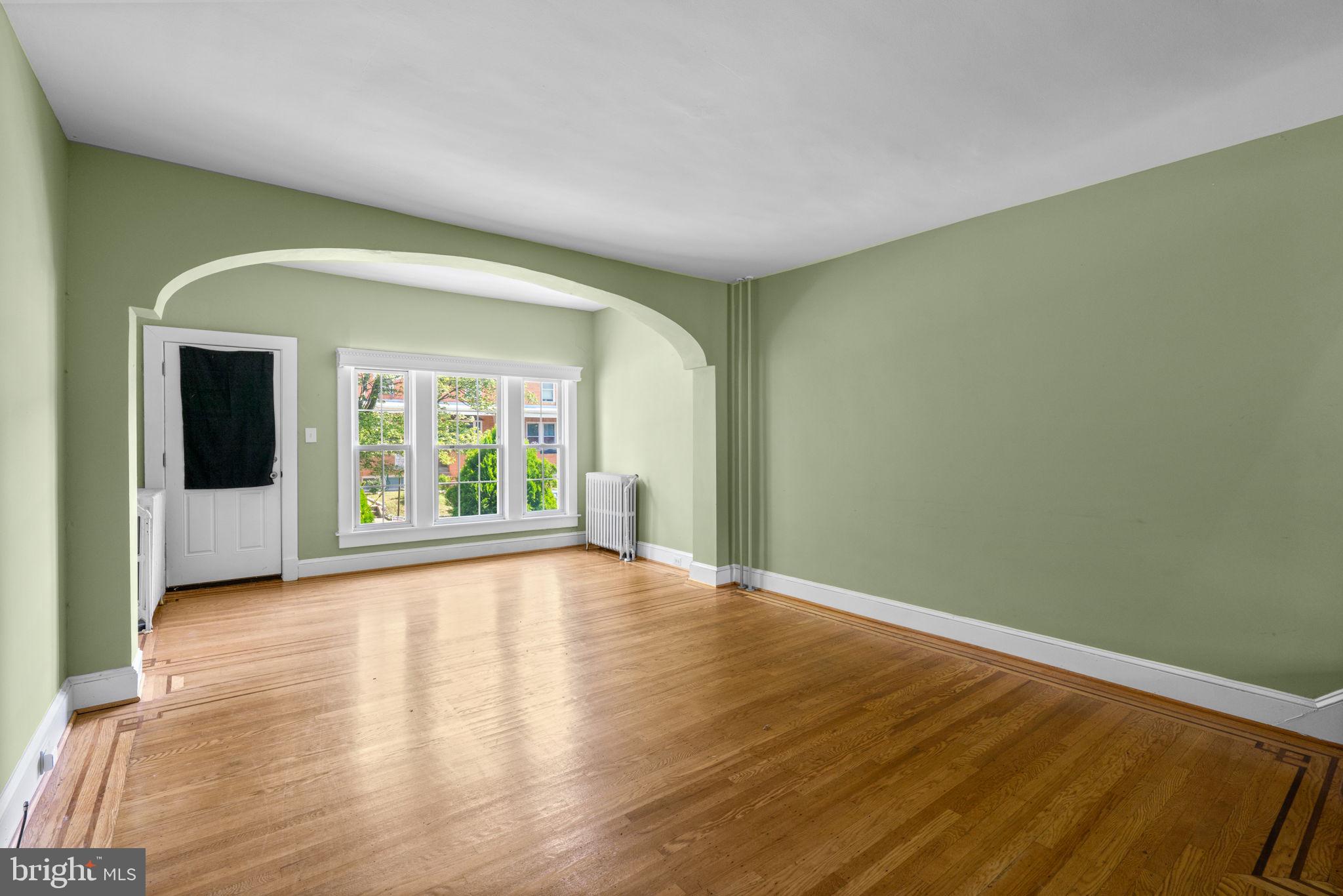 310 Drew Street Baltimore, MD 21224 - Photo 9 of 47 a view of an empty room with a window and wooden floor