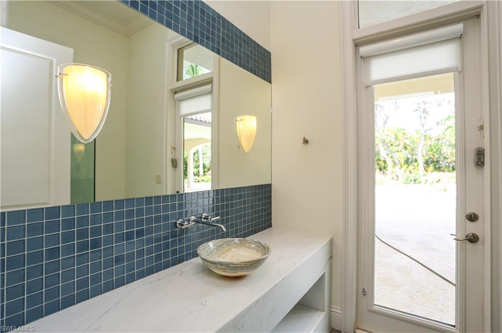 823 Cassena Road Naples, FL 34108 - Photo 18 of 50 a bathroom with a sink and a mirror
