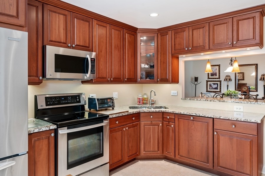 715 Ridge Road, Unit 3C Wilmette, IL 60091 - Photo 13 of 24 a kitchen with stainless steel appliances granite countertop a stove microwave and cabinets