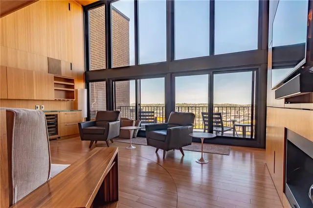 a living room with furniture floor to ceiling window and a table