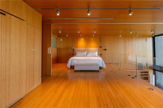 a spacious bedroom with a large window and a balcony