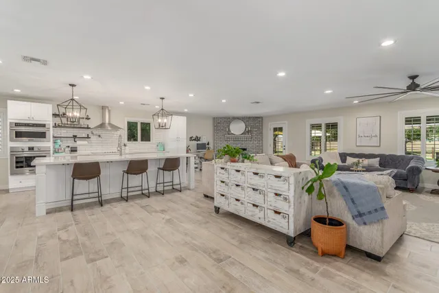 a large room with stainless steel appliances kitchen island granite countertop lots of counter space and windows