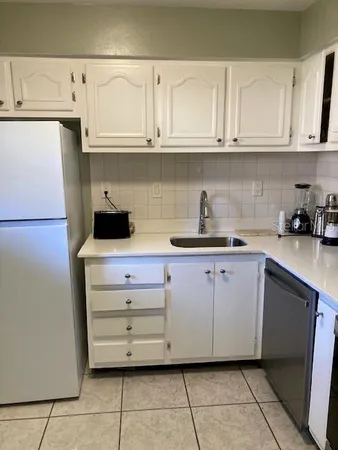 a kitchen with stainless steel appliances granite countertop a sink and a white cabinets