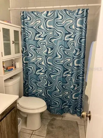 a white toilet sitting next to a shower curtain