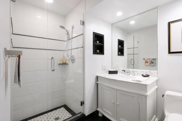 a bathroom with a sink a toilet and shower