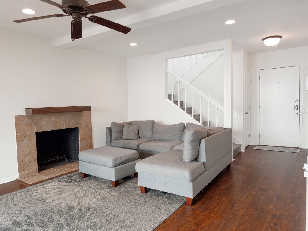 Living area featuring recessed lighting, wood finished floors, a tile fireplace, stairway, and ceiling fan