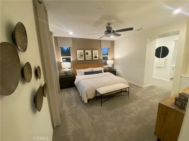 a bedroom with a bed a window and a chandelier