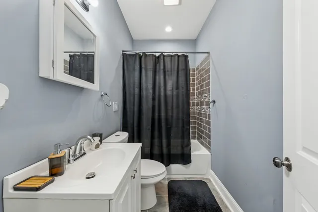 a living room with stainless steel appliances furniture wooden floor and a kitchen view