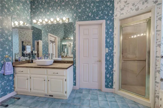 a bathroom with a granite countertop sink a mirror and a shower